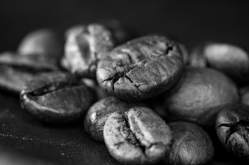 Brown roasted coffee beans on black background, close up, macro