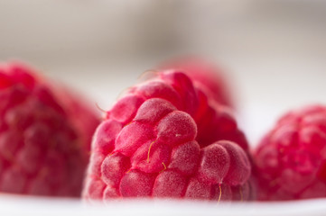 raspberries on a white saucer close up