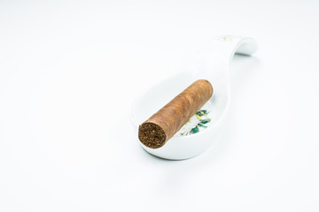 Gorgeous cigar from twisted sheets in the stand for the cook with white background.