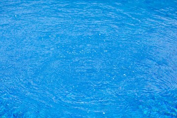 Fototapeta na wymiar water ripples in swimming pool, blue background