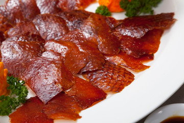 Peking duck or grilled duck skin served with fresh vegetable, sweet sauce and roasted wheaten Chinese pancakes.