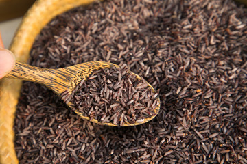 Organic Riceberry rice and wood spoon in weave basket, Food Background