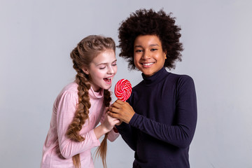 Cheerful African American boy playing with long-haired friend
