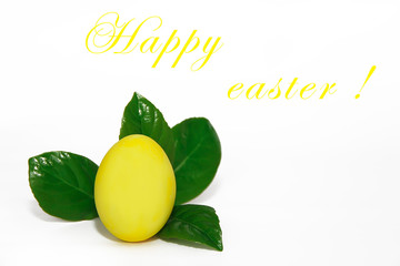 decorative yellow egg on green leaves for the holiday of holy Easter