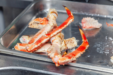 Closeup metal baking tray with carved fresh red big boiled prepared blue kamchatka crab. Concept useful seafood in menu premium restaurant preparing, serving for guests, clients