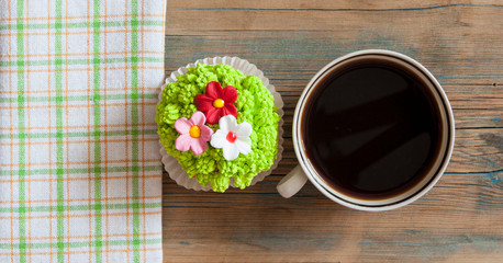 flower spring cupcake  with hot coffee cup on wooden table