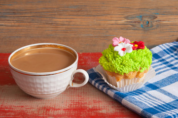 Obraz na płótnie Canvas flower spring cupcake with hot coffee cup on wooden table