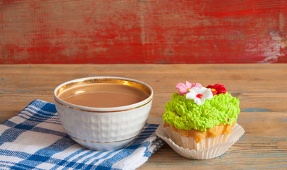 flower spring cupcake  with hot coffee cup on wooden table