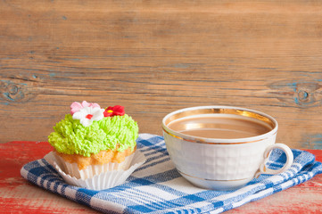 flower spring cupcake  with hot coffee cup on wooden table