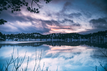 Sunset and reflections over a frozen lake in Norway