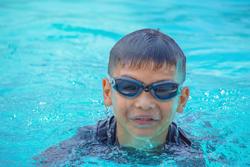 Asian boy learned to swim in the pool.