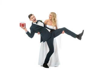 excited bride and groom with gift box having fun isolated on white