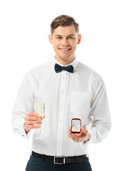 happy groom holding glass of champagne and gift box with wedding ring isolated on white