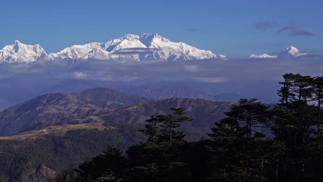 Kangchenjunga mount Time lapse wide angle of fog moving in front of mountain at blue sky day, Zoom in.