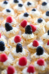 details of wedding treats with white cream and black berries and raspberries