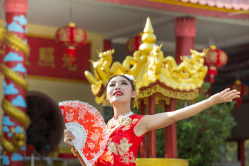 Asian woman with hinese traditional dress cheongsam holding chinese paper fan.