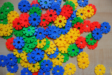Color children's round meccano  on a light wooden background. perfect background for inscriptions, designs and banners