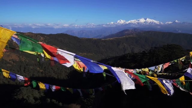 Tibetan prayer flag or Lung ta and Kangchenjunga high mountain range view from the Sandakphu , Darjeeling,  India, Zoom out.