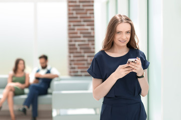 young woman uses her smartphone in the office