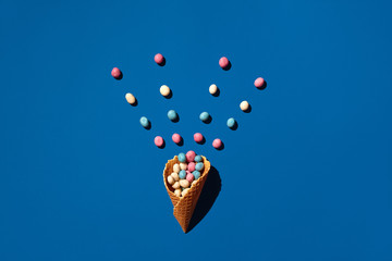 An image of a heap of dragee sweets that is sprinkled from a waffle cone