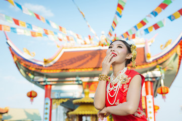 A beautiful asian girl wearing a red suit showing her gestures and smiling makes her look happy.