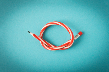 Flexible pencil . Isolated on blue background. Bending pencil.