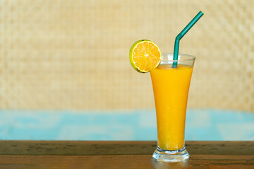 Fresh orange juice in glass on wooden table.