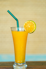 Fresh orange juice in glass on wooden table.