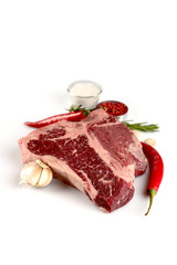 raw t-bone steak pepper salt rosemary garlic