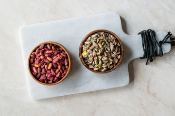 Raw and Roasted Wooden Bowl of Peeled Pistachios without Shell / with No Shell