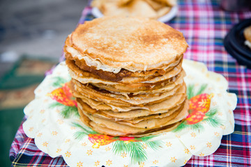 Fried pancakes are a mountain on a plate of sweets for a healthy breakfast. Shrovetide