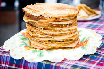Fried pancakes are a mountain on a plate of sweets for a healthy breakfast. Shrovetide