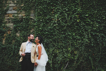 bride and groom in front of nature wall