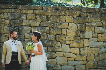 bride and groom in front of brick wall