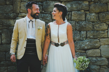 bride and groom on stone wall