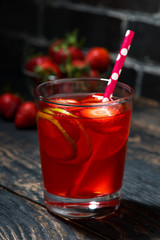 glass of strawberry lime lemonade on a dark wooden background, vertical closeup