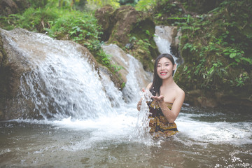 Happy bathing women at the natural waterfall.