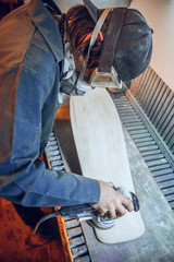 Carpenter using circular saw for cutting wooden boards. Construction details of male worker or handy man with power tools