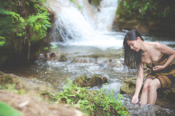 Fototapeta na wymiar Happy bathing women at the natural waterfall.