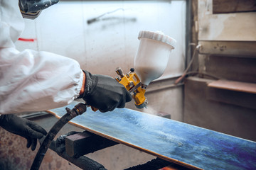 Master painter in a factory - industrial painting wood with spray gun. - obrazy, fototapety, plakaty