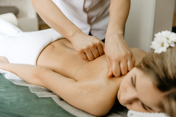 Fototapeta na wymiar Masseur doing back massage to young woman.