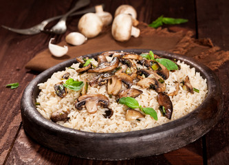 Cooked white rice with mushroomsin a bowl on wooden background.