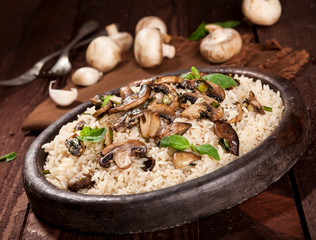 Cooked white rice with mushroomsin a bowl on wooden background.