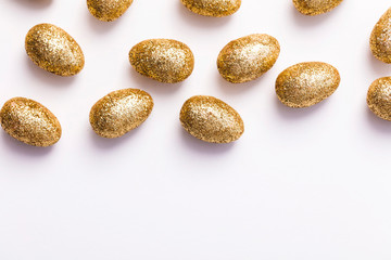 Gold glitter easter eggs on a plain white background