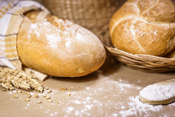 Freshly baked bread, wheat and flour on a rustic background
