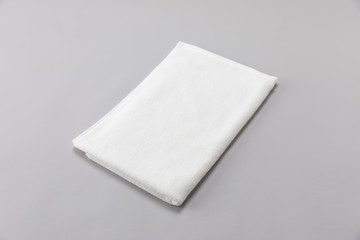 White single towel folded on gray background