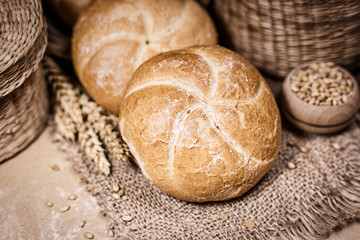 Fresh bread and wheat on a rustic background