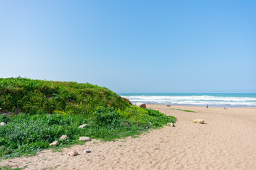 Fototapeta na wymiar Beach in Casablanca Morocco with a Green Mound and the Atlantic Ocean