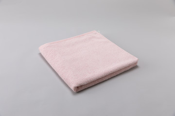 pink single towel folded on gray background