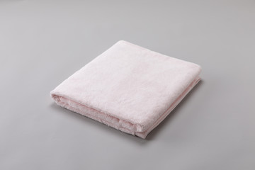 pink single towel folded on gray background